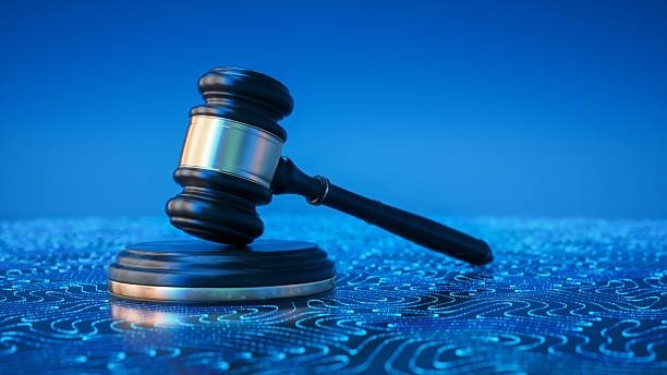Judge’s gavel on a glowing blue digital circuit-board surface